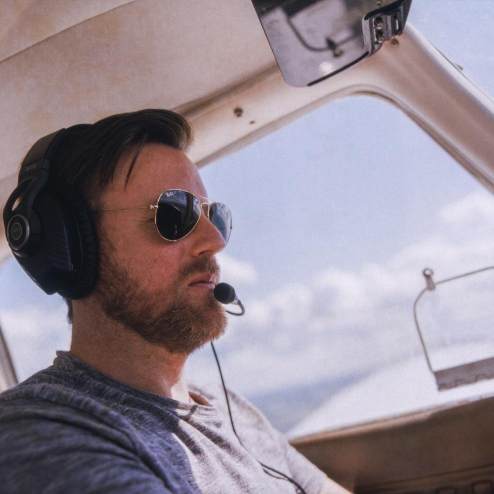 Middle aged man flying a light plane